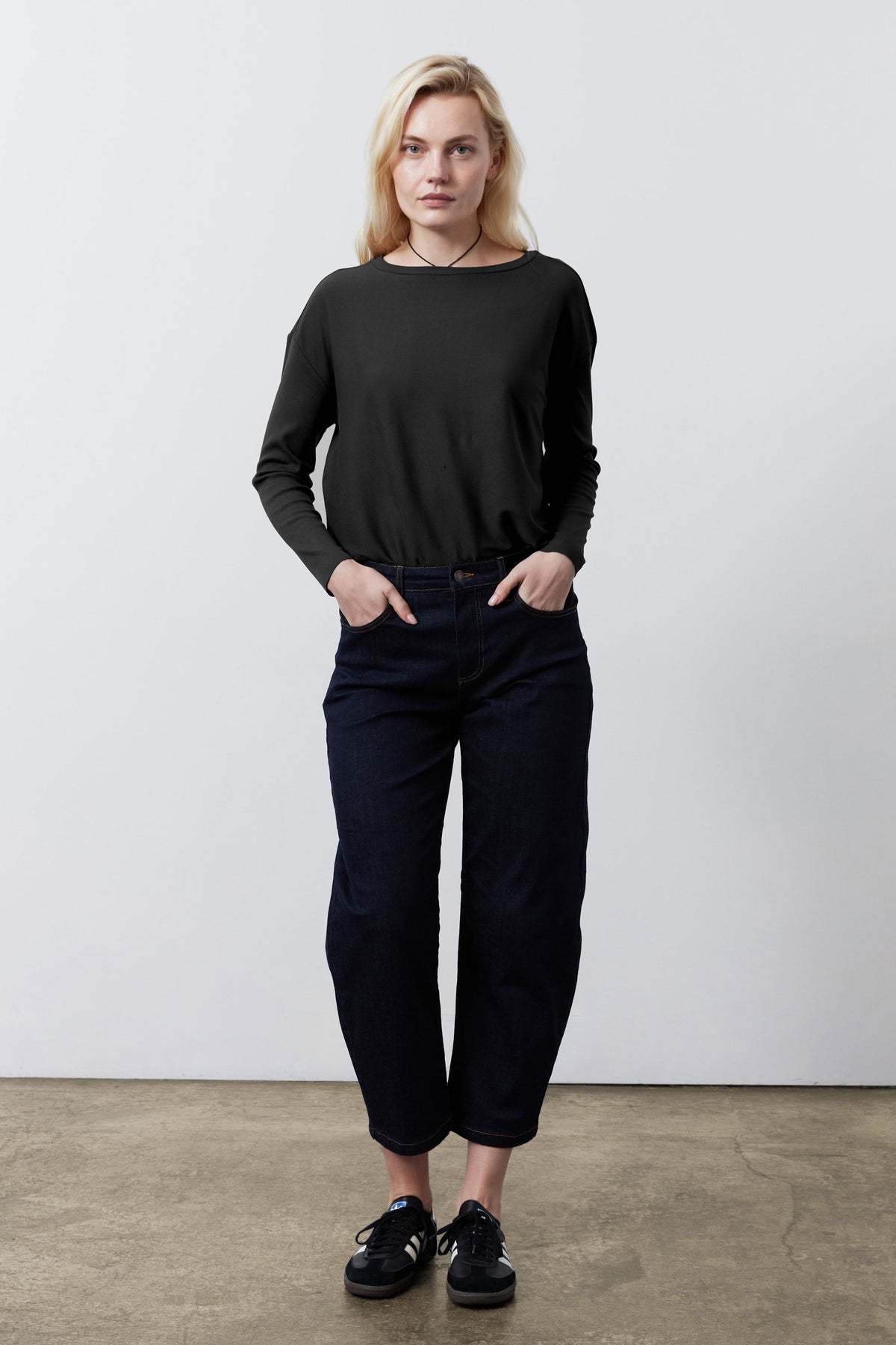 Black long-sleeve top with rounded neckline, straight hem, and easy drape
