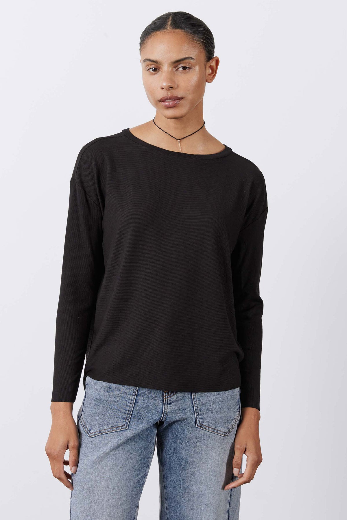 Black long-sleeve essential top with relaxed shoulders and rounded neckline