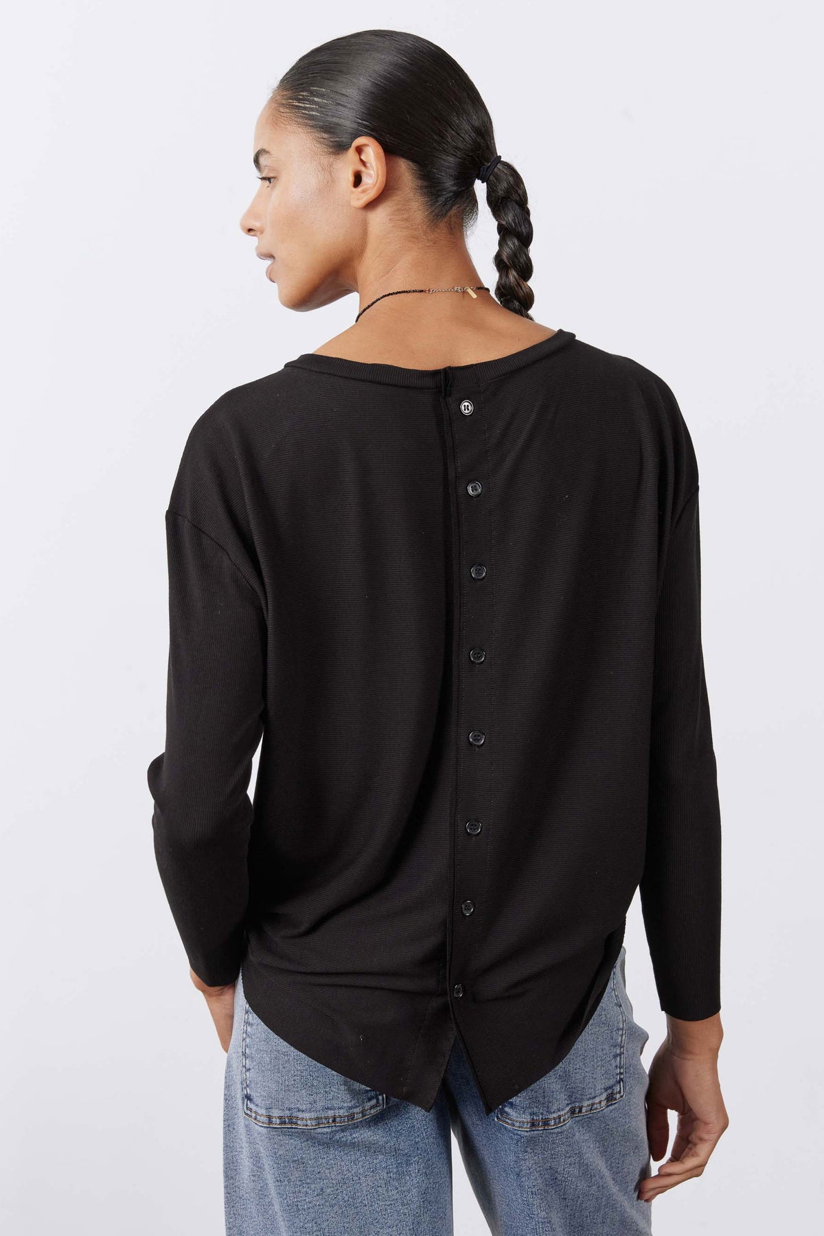 Black long-sleeve top viewed from back with button placket detail