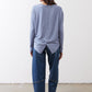 Light blue long-sleeve top with buttoned back and gathered knot hem