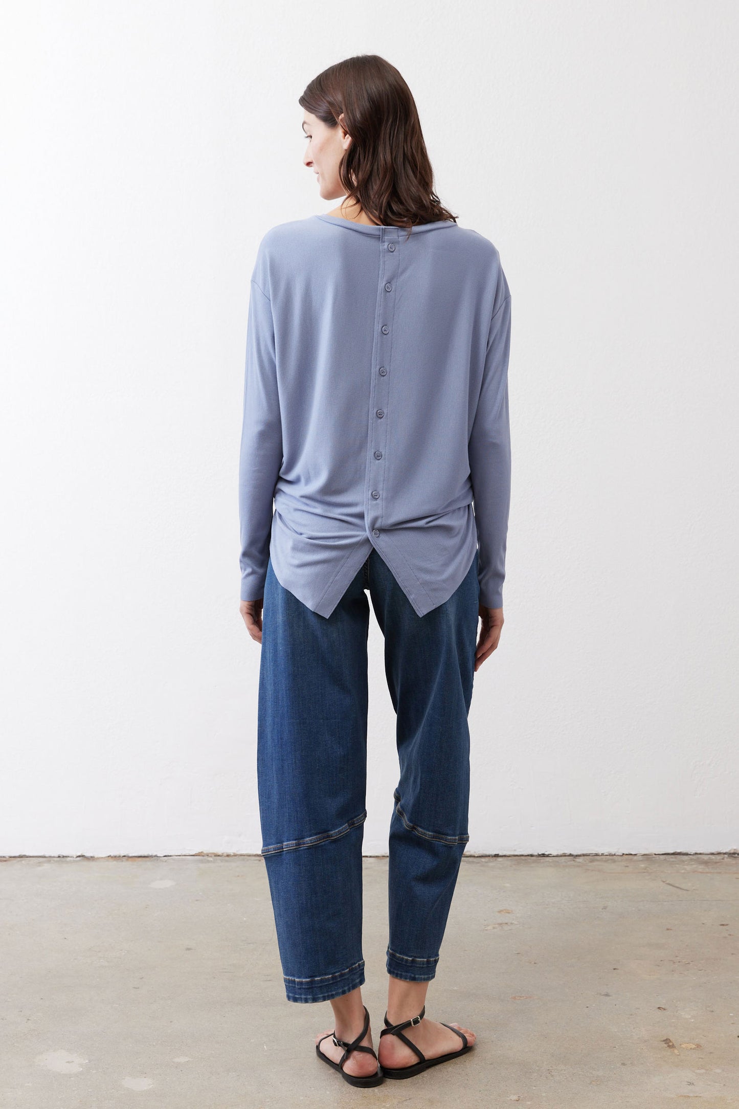 Light blue long-sleeve top with buttoned back and gathered knot hem