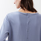 Light blue back button placket on a long-sleeve crewneck top