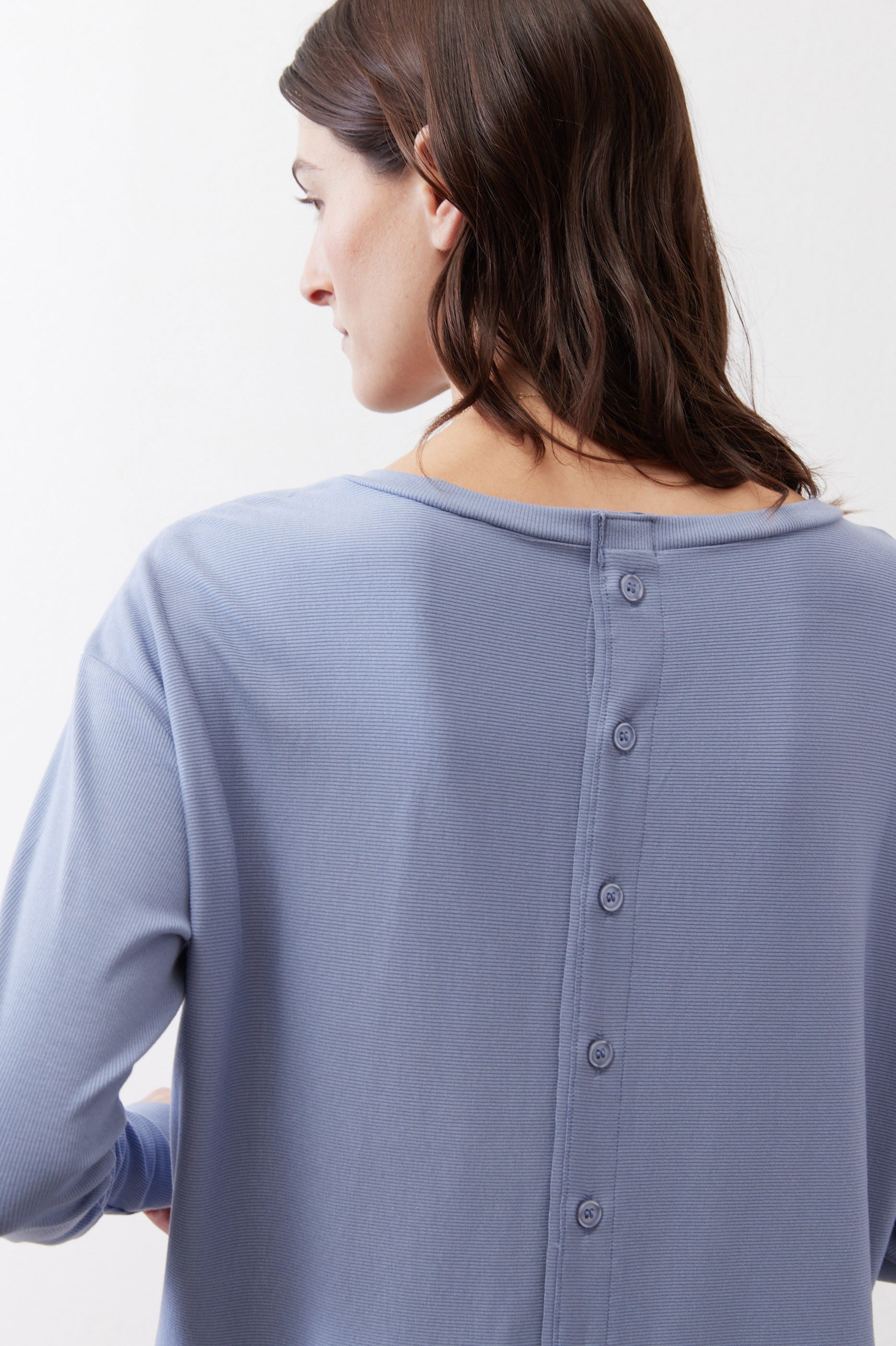 Light blue back button placket on a long-sleeve crewneck top