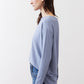 Light blue long-sleeve crewneck top with draped side silhouette