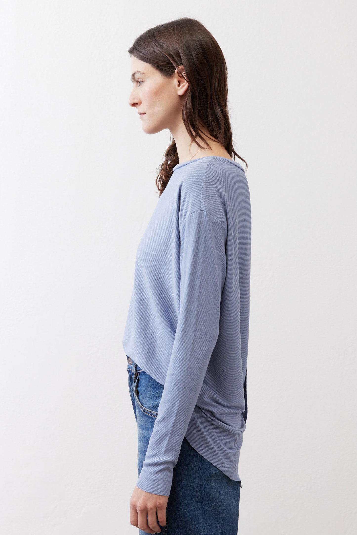 Light blue long-sleeve crewneck top with draped side silhouette