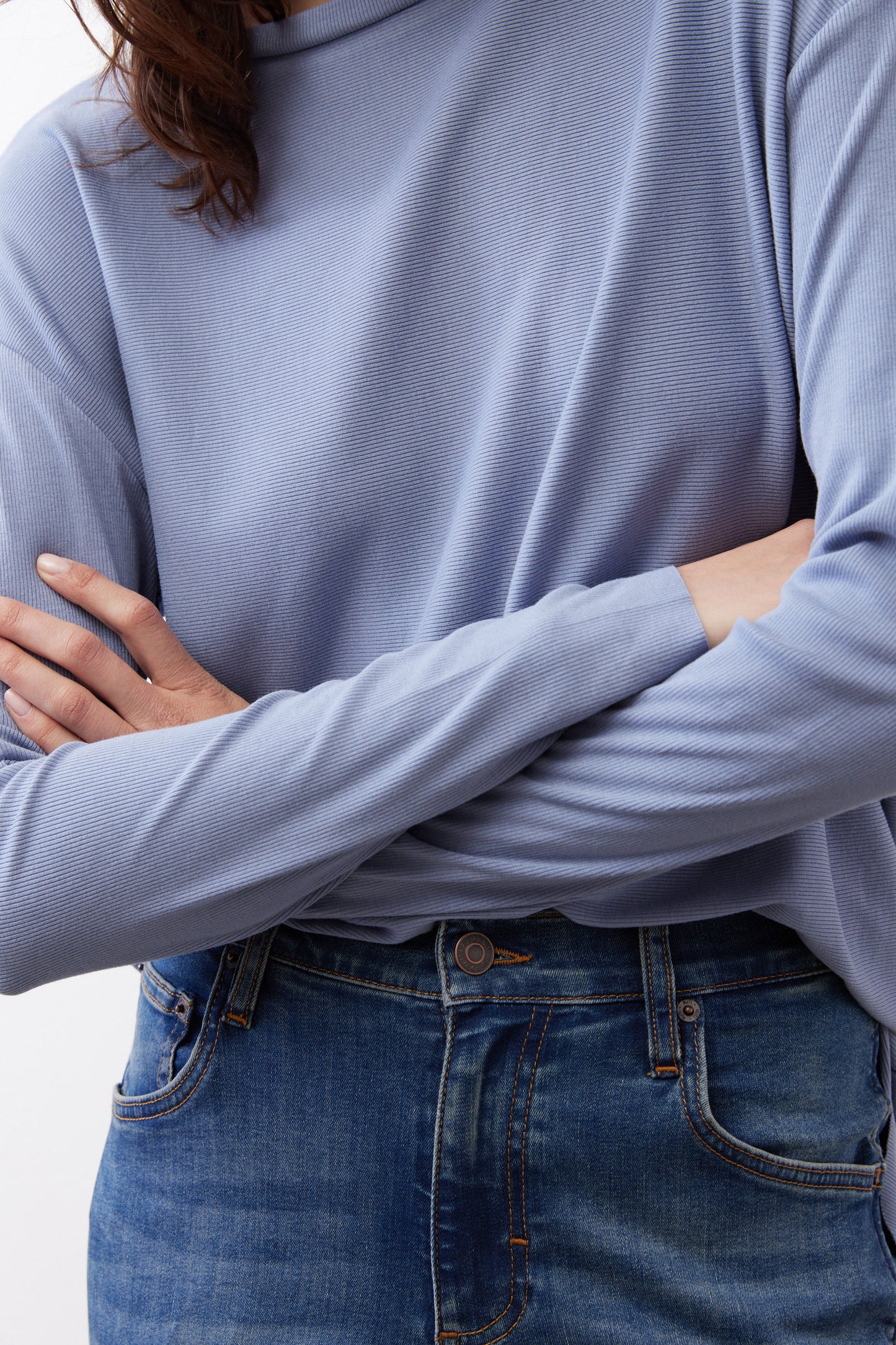 Light blue long-sleeve crewneck top with visible ribbed texture and sleeve cuff