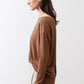 Deep brown long-sleeve crew-neck top, side view with relaxed drape