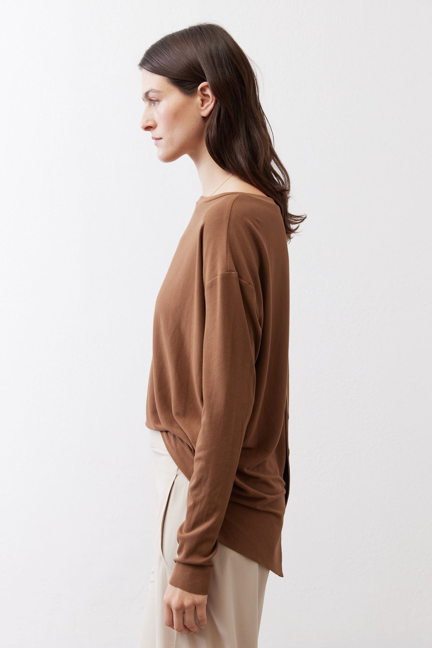 Deep brown long-sleeve crew-neck top, side view with relaxed drape