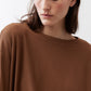 Deep brown crew-neck long-sleeve top close-up, smooth knit fabric
