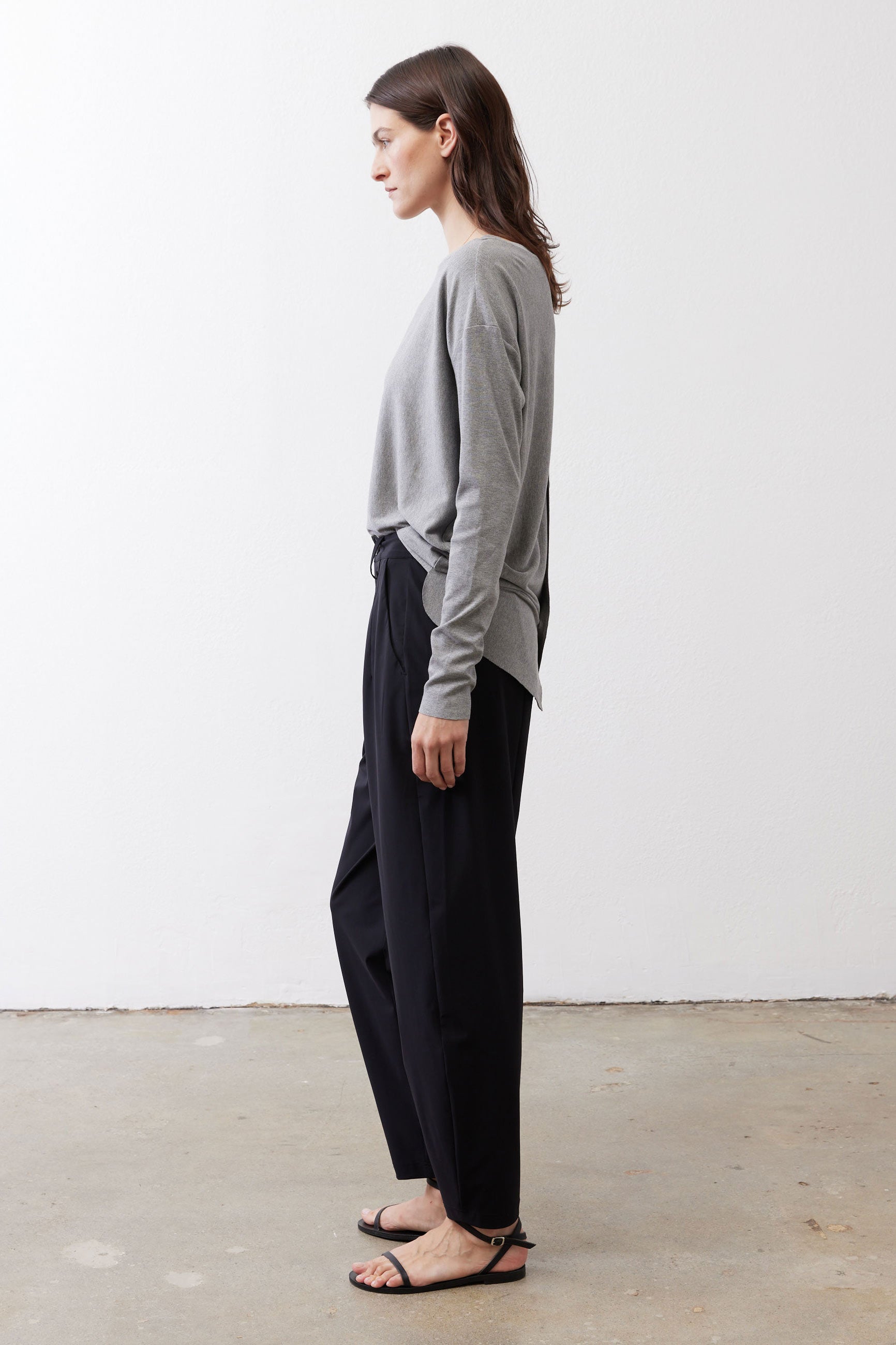 Gray melange long-sleeve crewneck top with knotted hem detail, side view