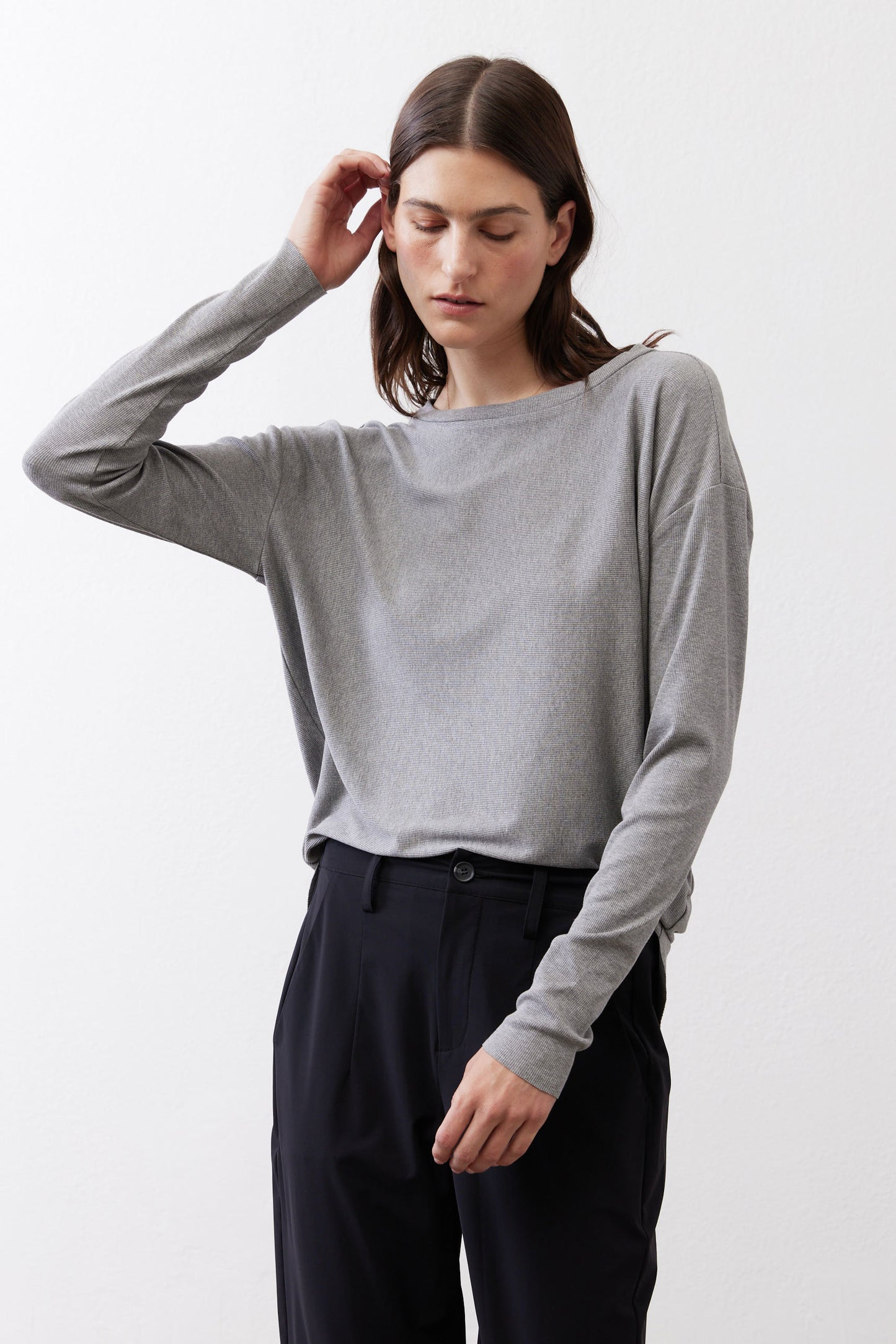 Gray melange long-sleeve crewneck top, front view with arm raised