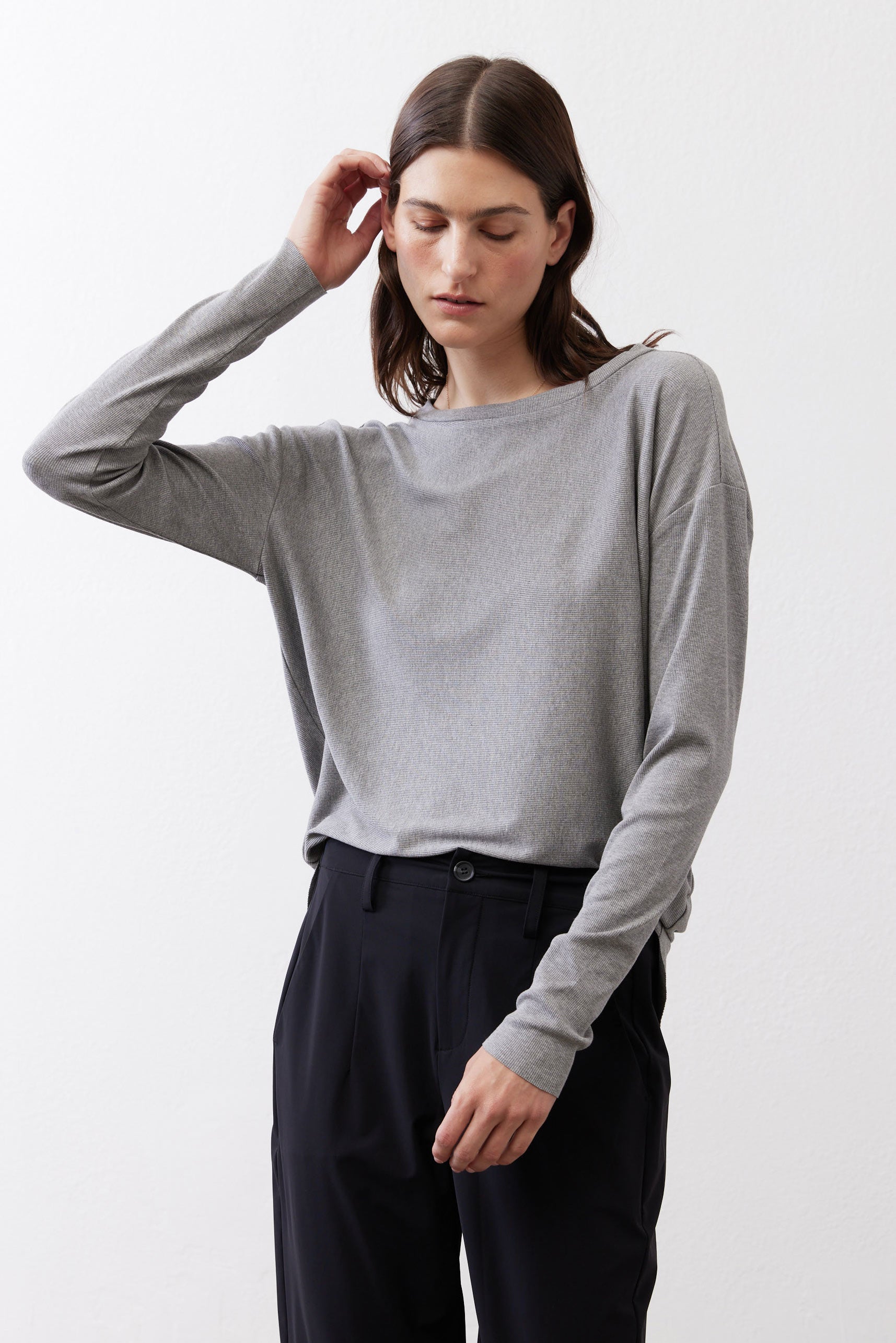 Gray melange long-sleeve crewneck top, front view with arm raised