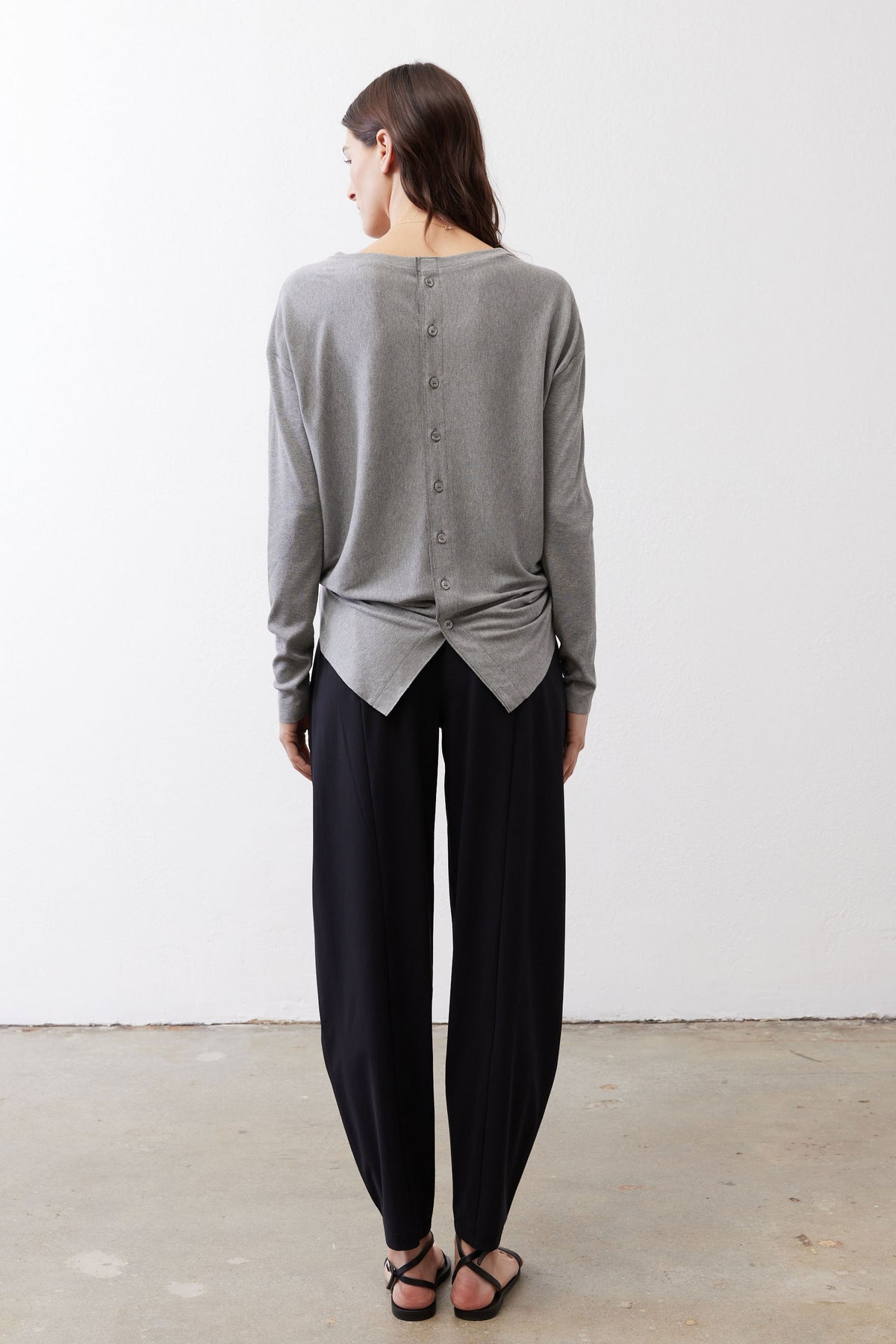 Gray melange long-sleeve top, back view, with buttons and gathered knot hem