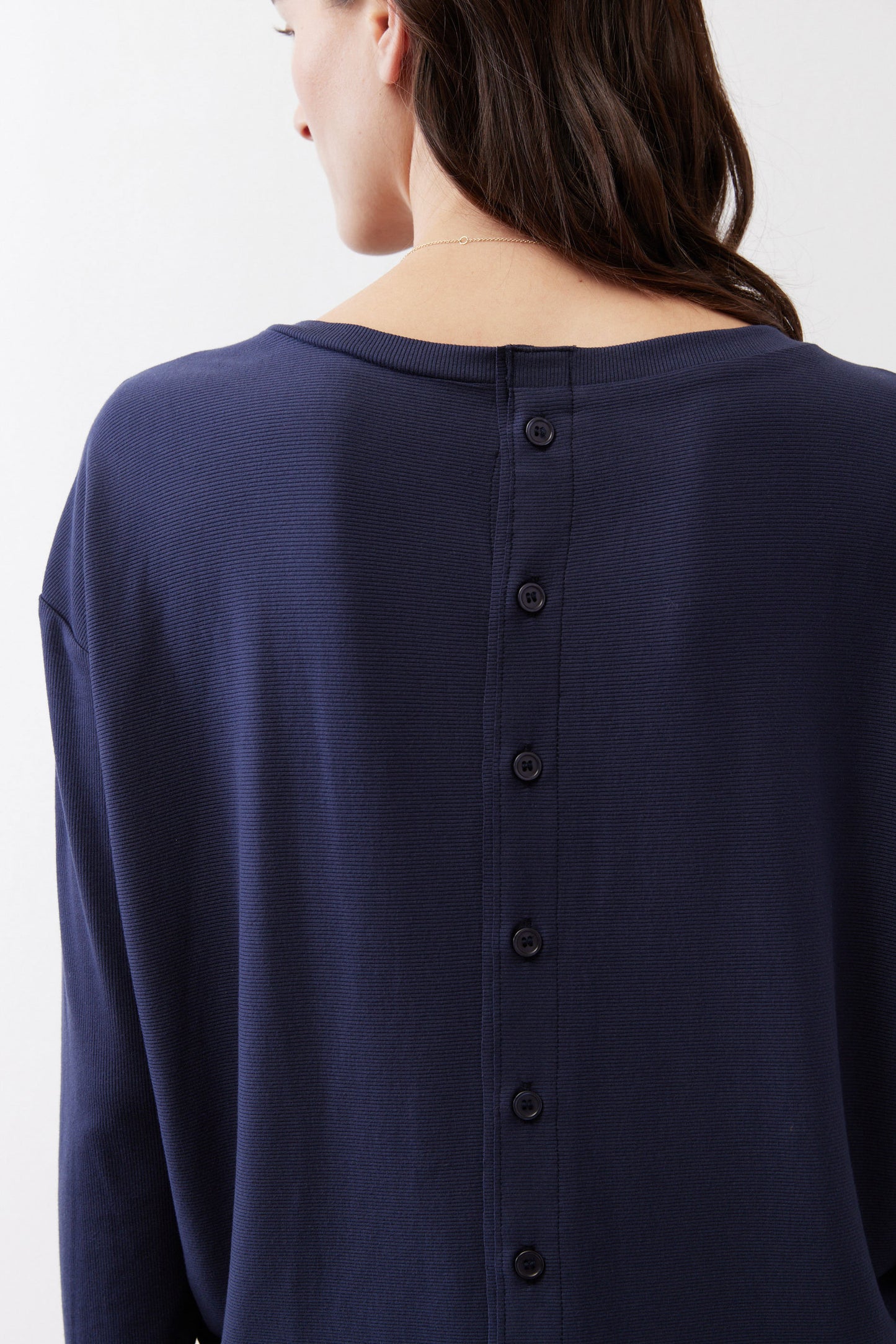 Deep navy long-sleeve top back with vertical button placket close-up