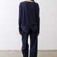 Deep navy long-sleeve top back with vertical buttons and knotted back hem