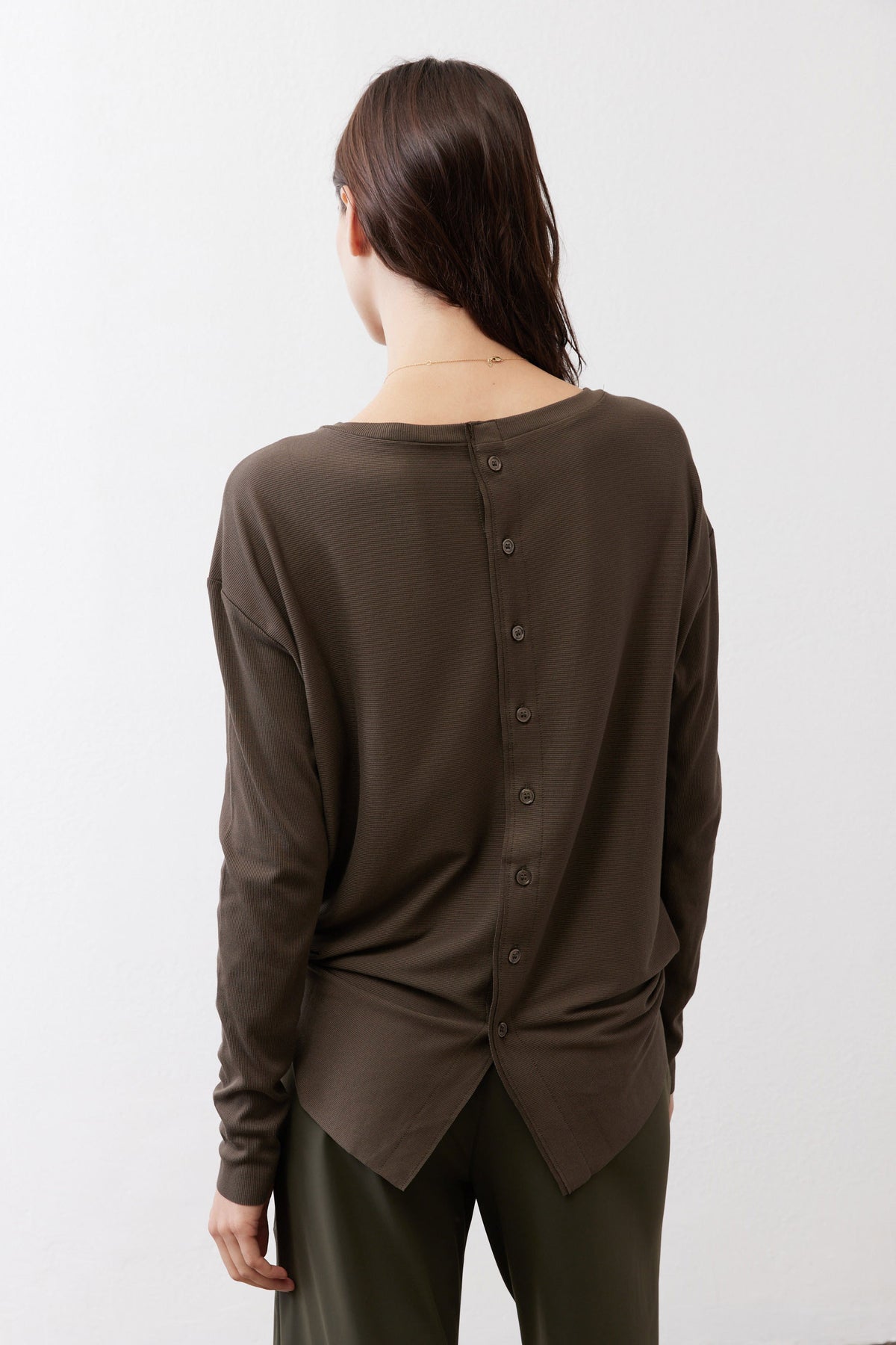 Olive long-sleeve top with buttoned back opening and slightly curved hem