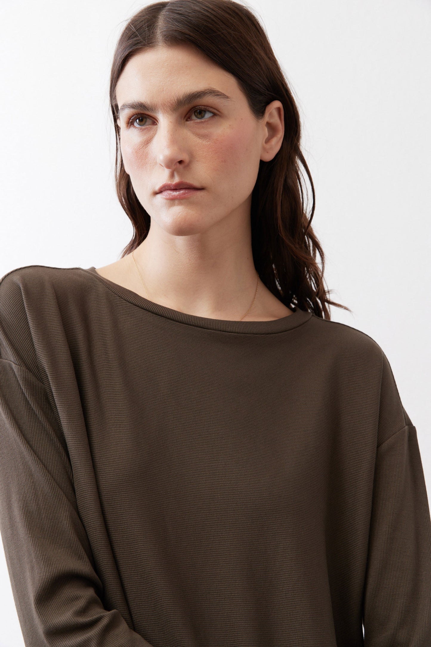Dark olive long-sleeve top with round neckline and relaxed fit