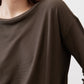 Dark olive top close-up at round neckline and shoulder seam