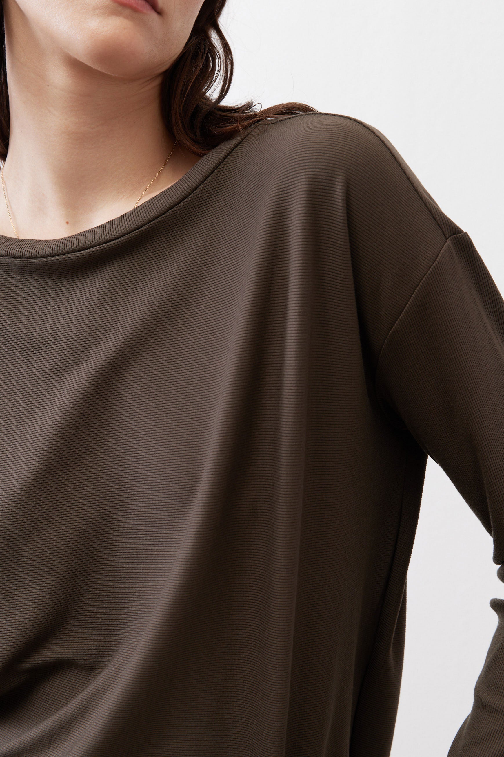 Dark olive top close-up at round neckline and shoulder seam