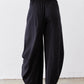 Black wide-leg pants with elastic waistband and loose back drape to ankle hem