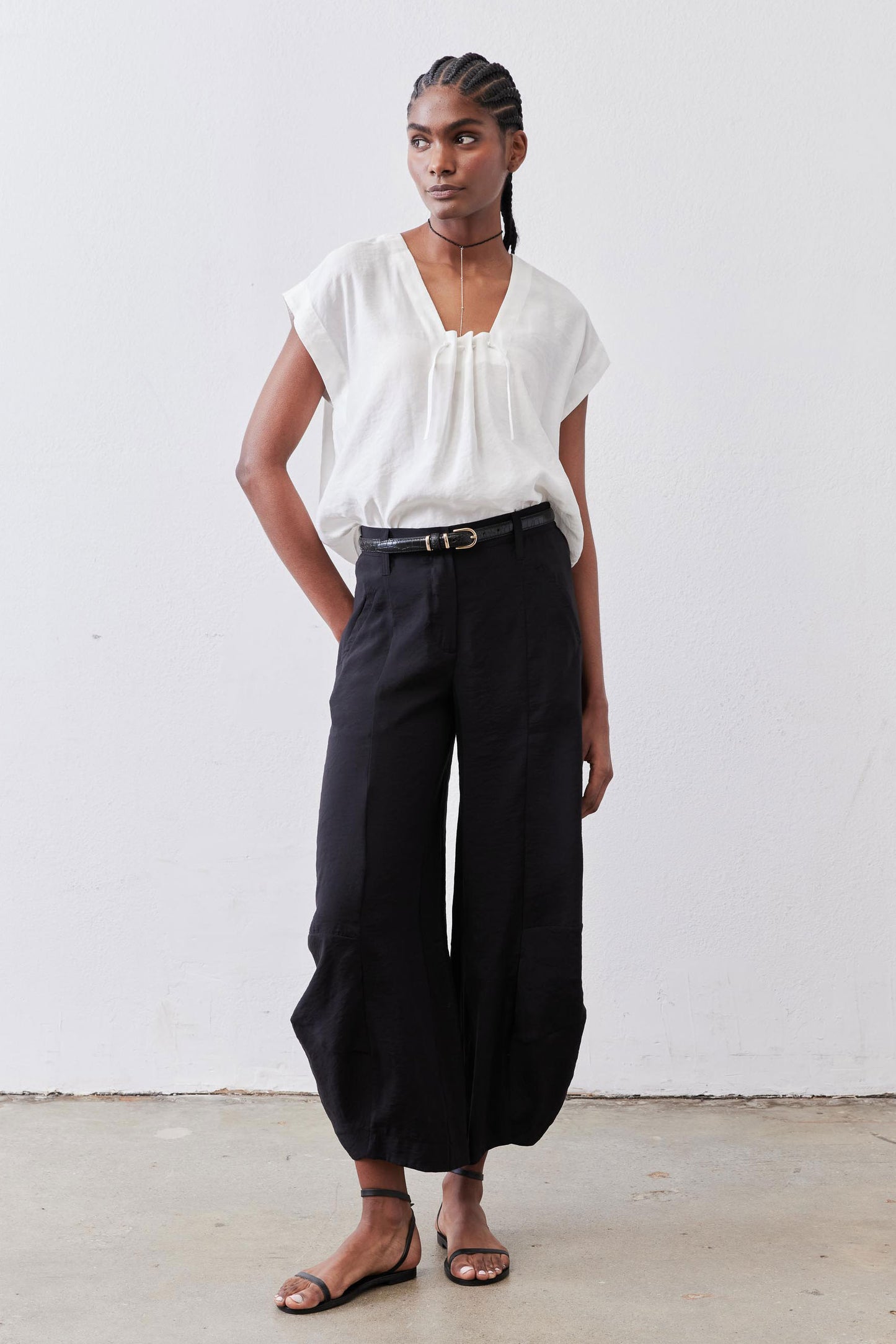 Black wide-leg pants with elastic waistband, side pockets, and ankle-length hem