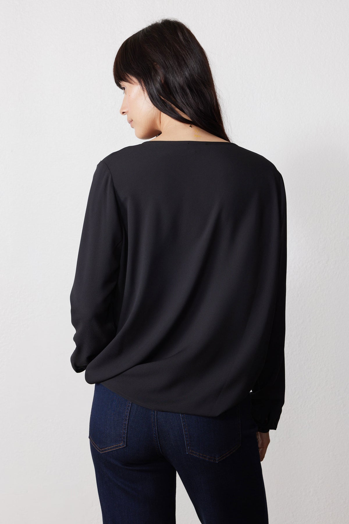 Black long-sleeve V-neck top from back, straight hem and full sleeves