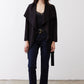 Black draped jacket with tie belt over dark jeans, open front.
