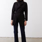 Black belted jacket with high neckline, long sleeves, and asymmetrical drape.