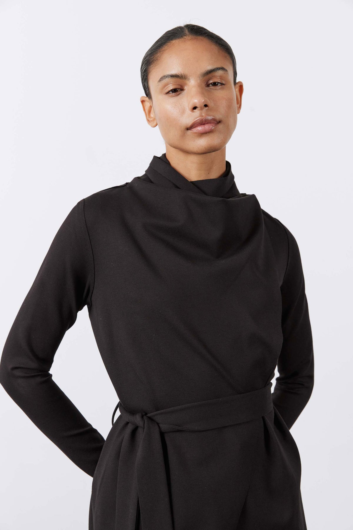 Black draped jacket close-up with high neck and waist belt tie