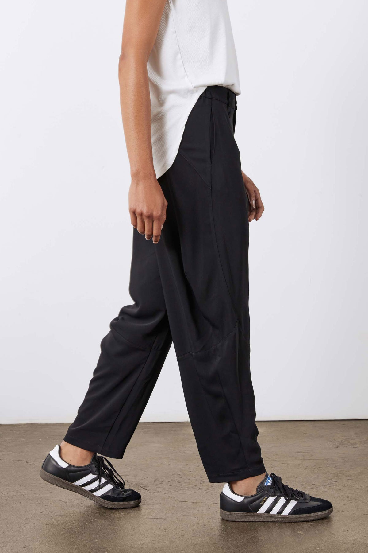 Black wide-leg formal pants in profile view with elastic waistband and pockets