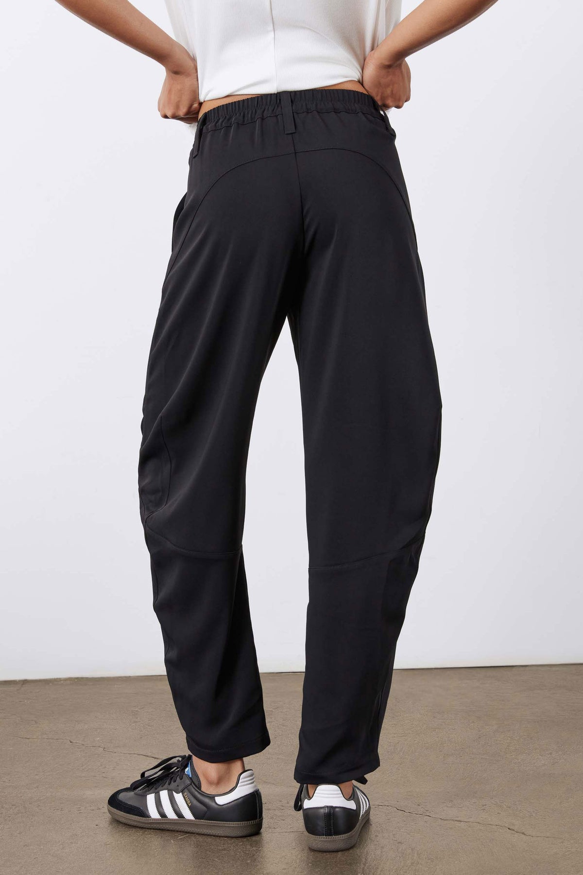 Black wide-leg formal pants, draped fabric with elastic waist and cuffed hem