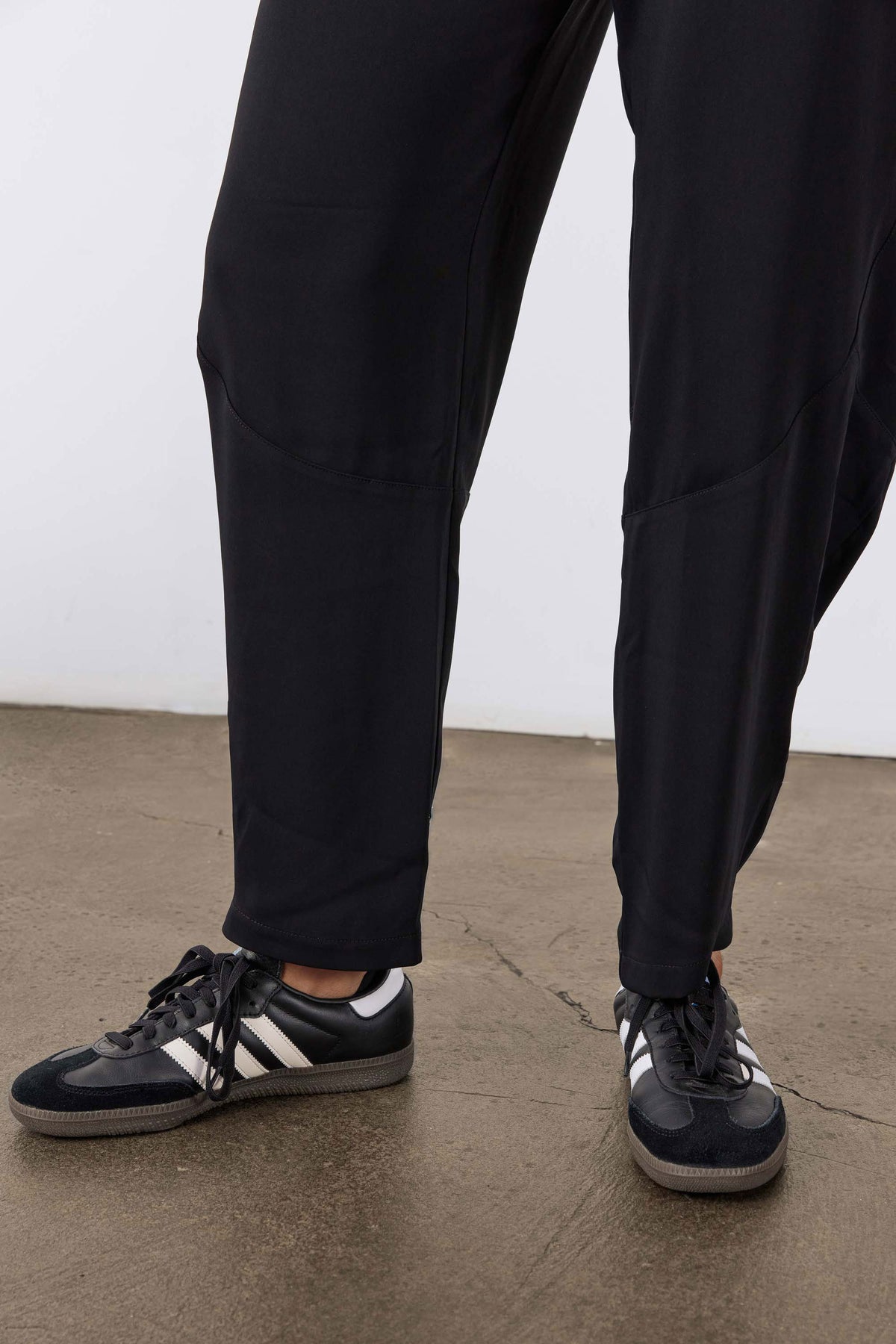 Black wide-leg formal pants showing ankle length and gathered hem