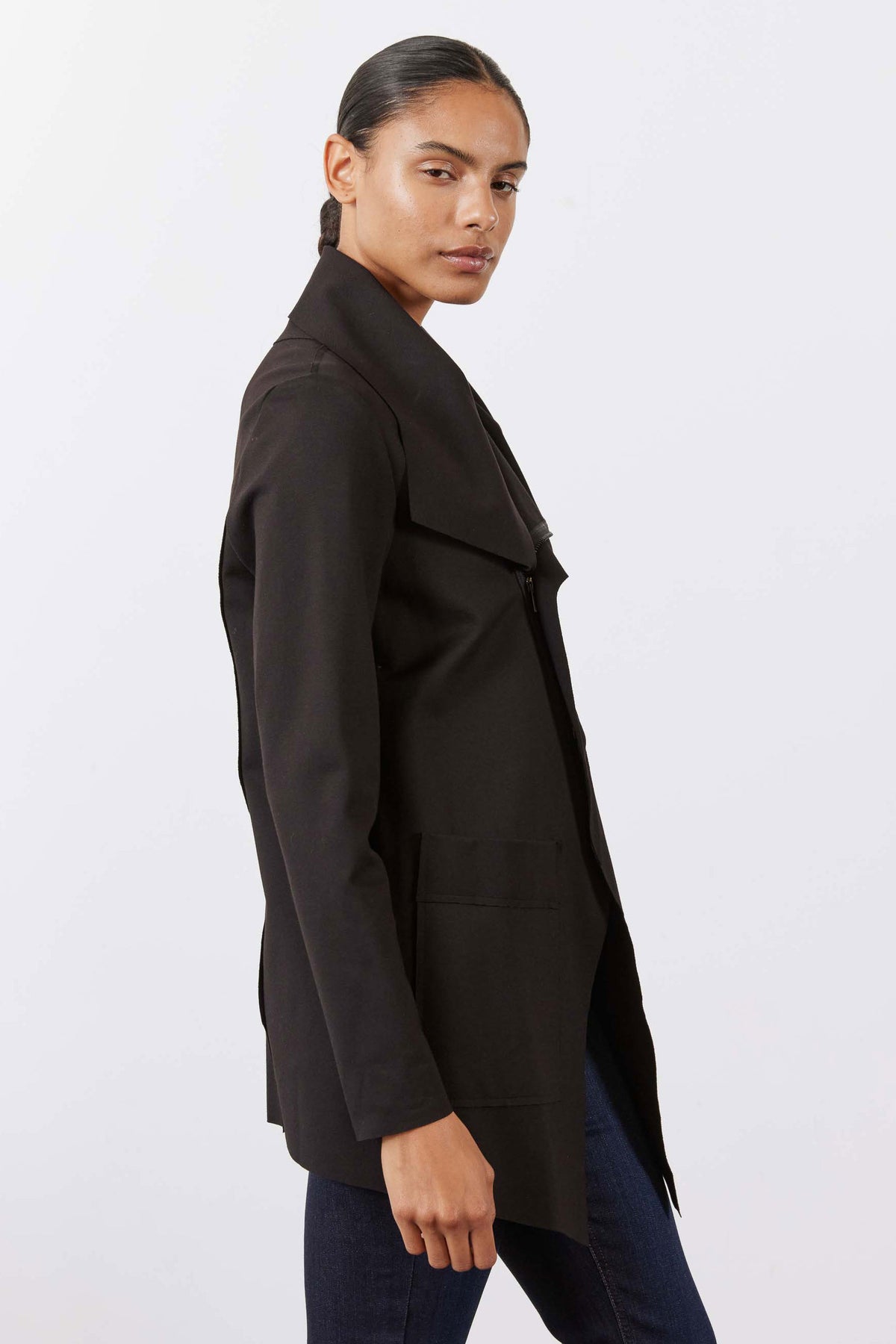Black jacket worn open over jeans, side profile with long sleeves