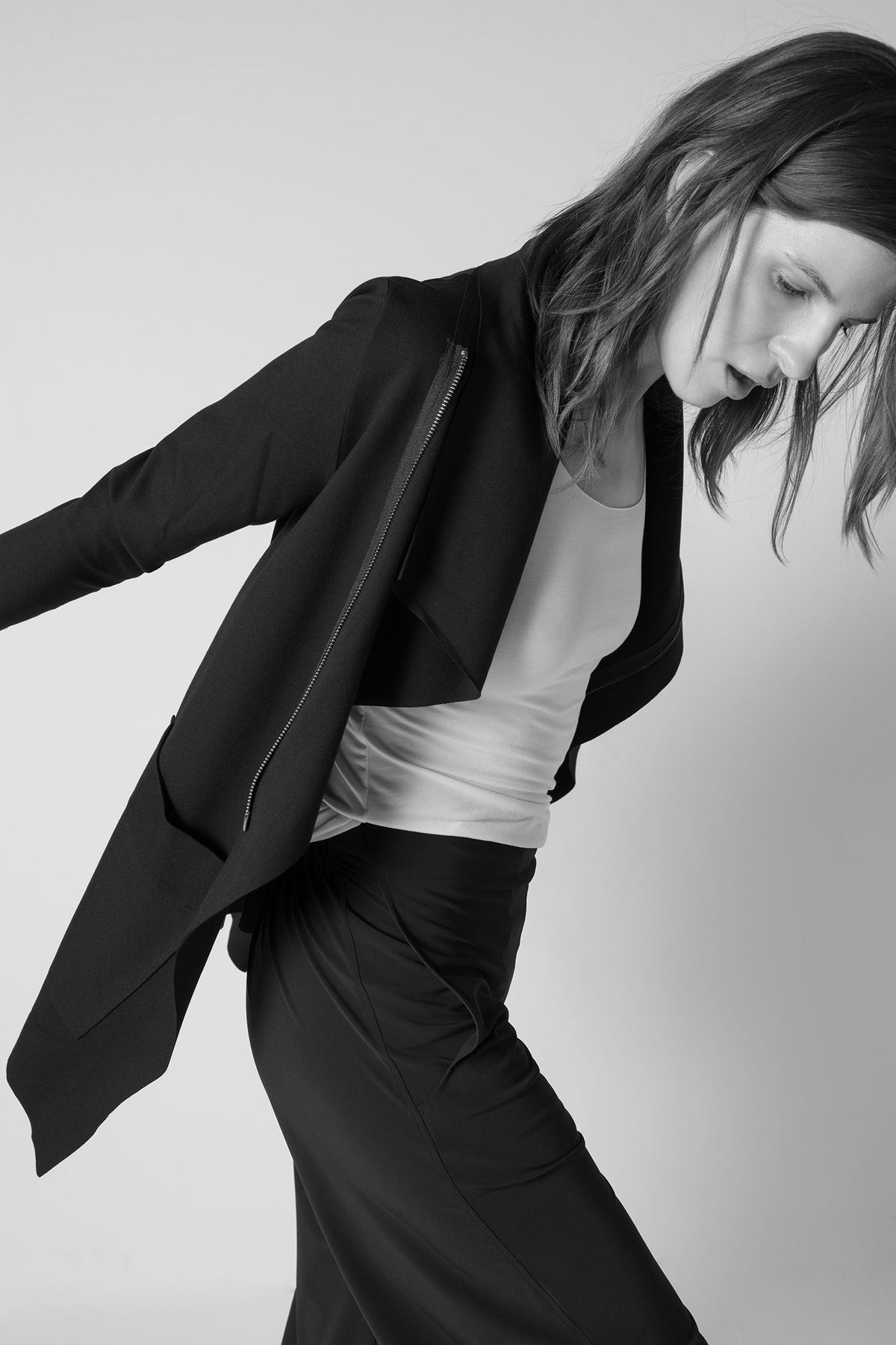 Black jacket draped open at chest with long sleeves and asymmetric collar