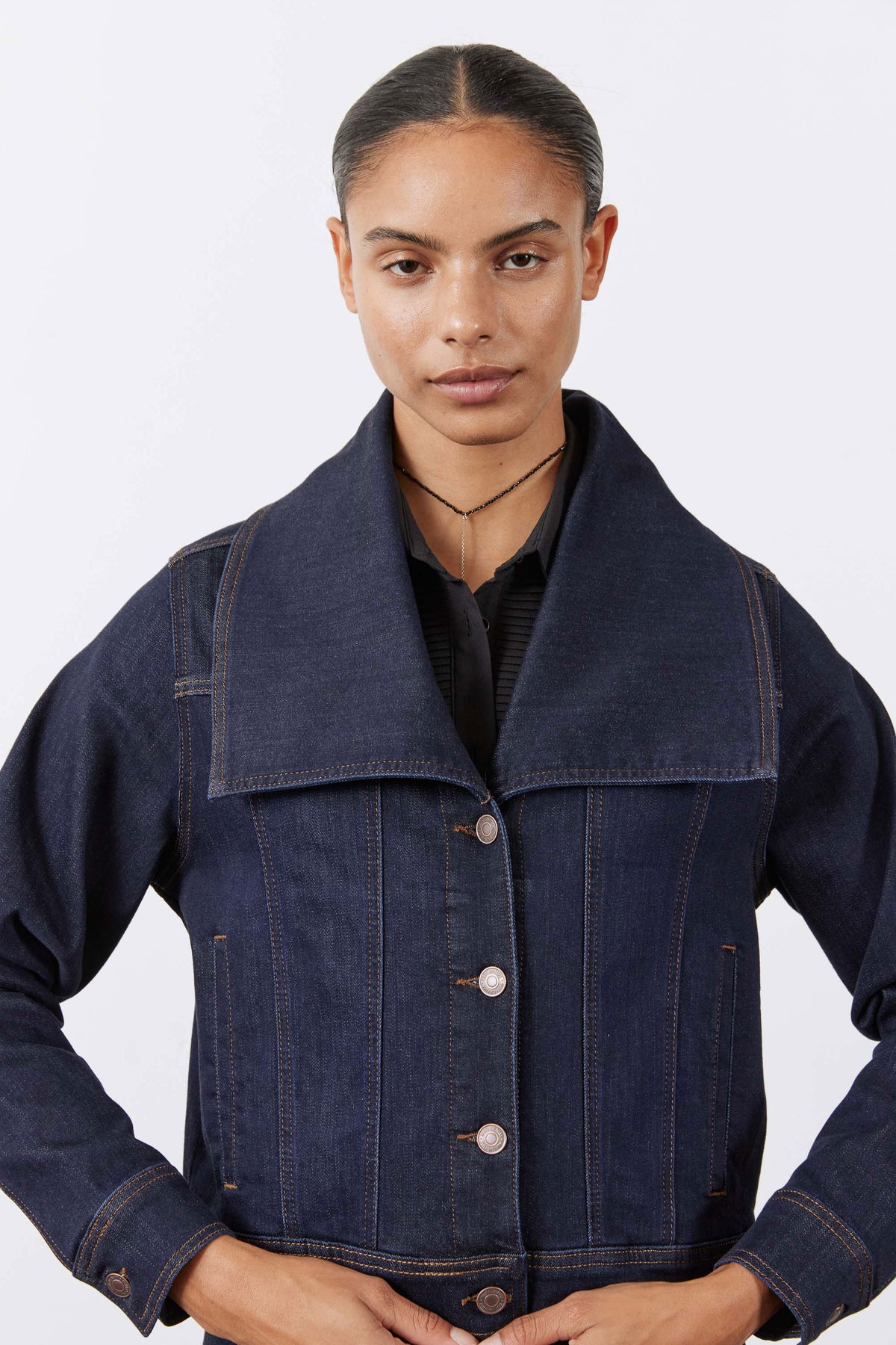 Dark denim jacket with stand collar, button front, and two chest flap pockets