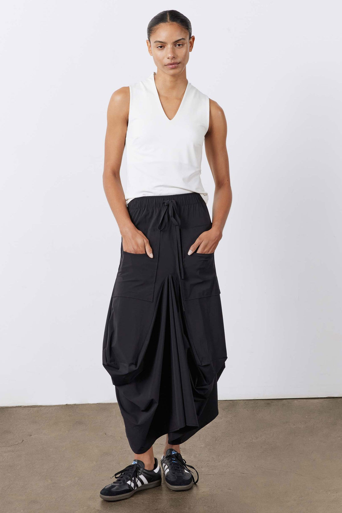 Black midi skirt with drawstring waist and layered, draped cargo-style pockets