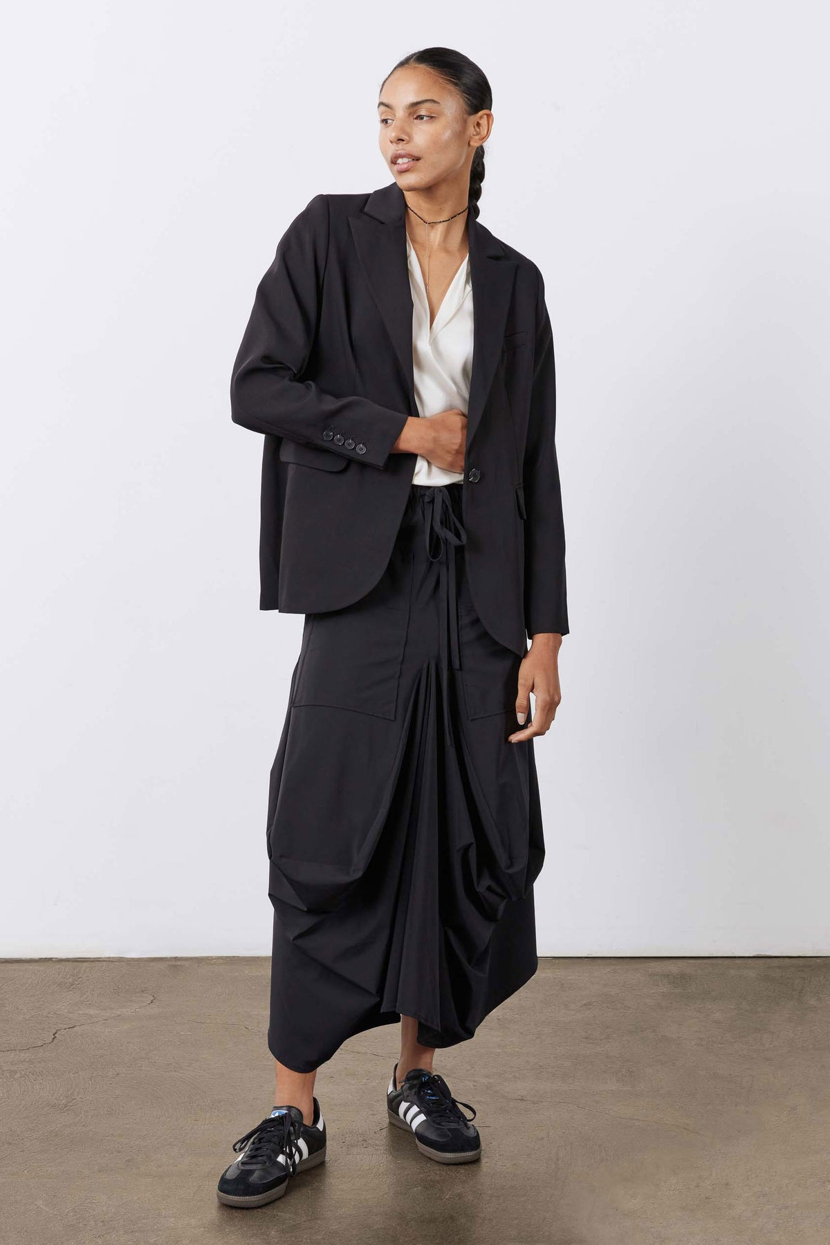 Black midi skirt with elastic drawstring waist and draped, pocketed silhouette