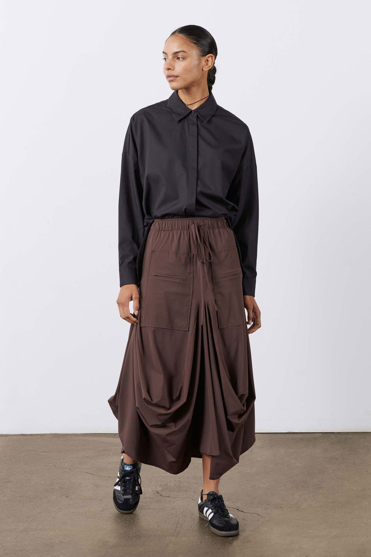 Coffee-brown midi skirt with gathered elastic waist, drawstring, and layered pocket details