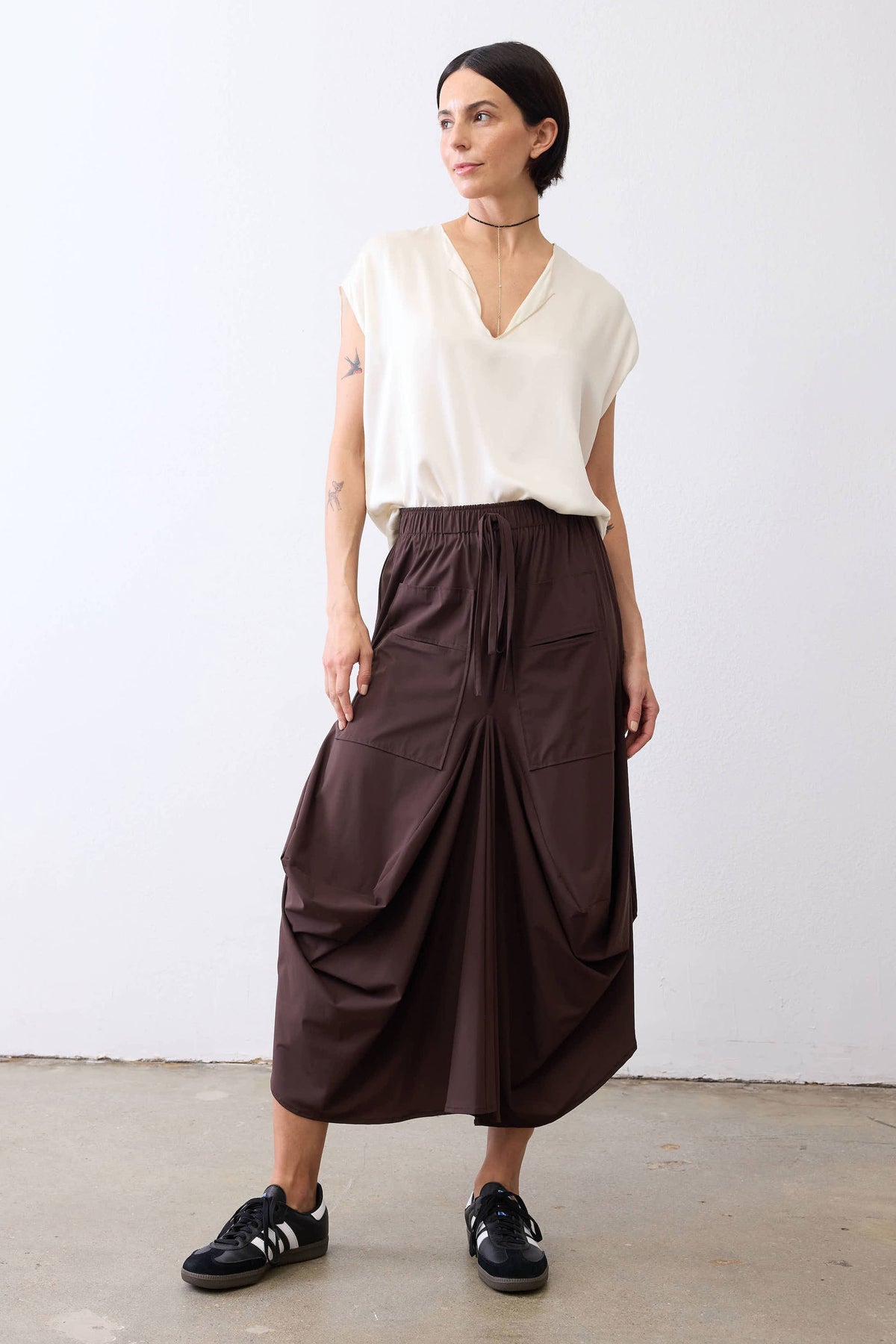Coffee-brown petite midi skirt with elastic waist, drawstring, and draped panel front