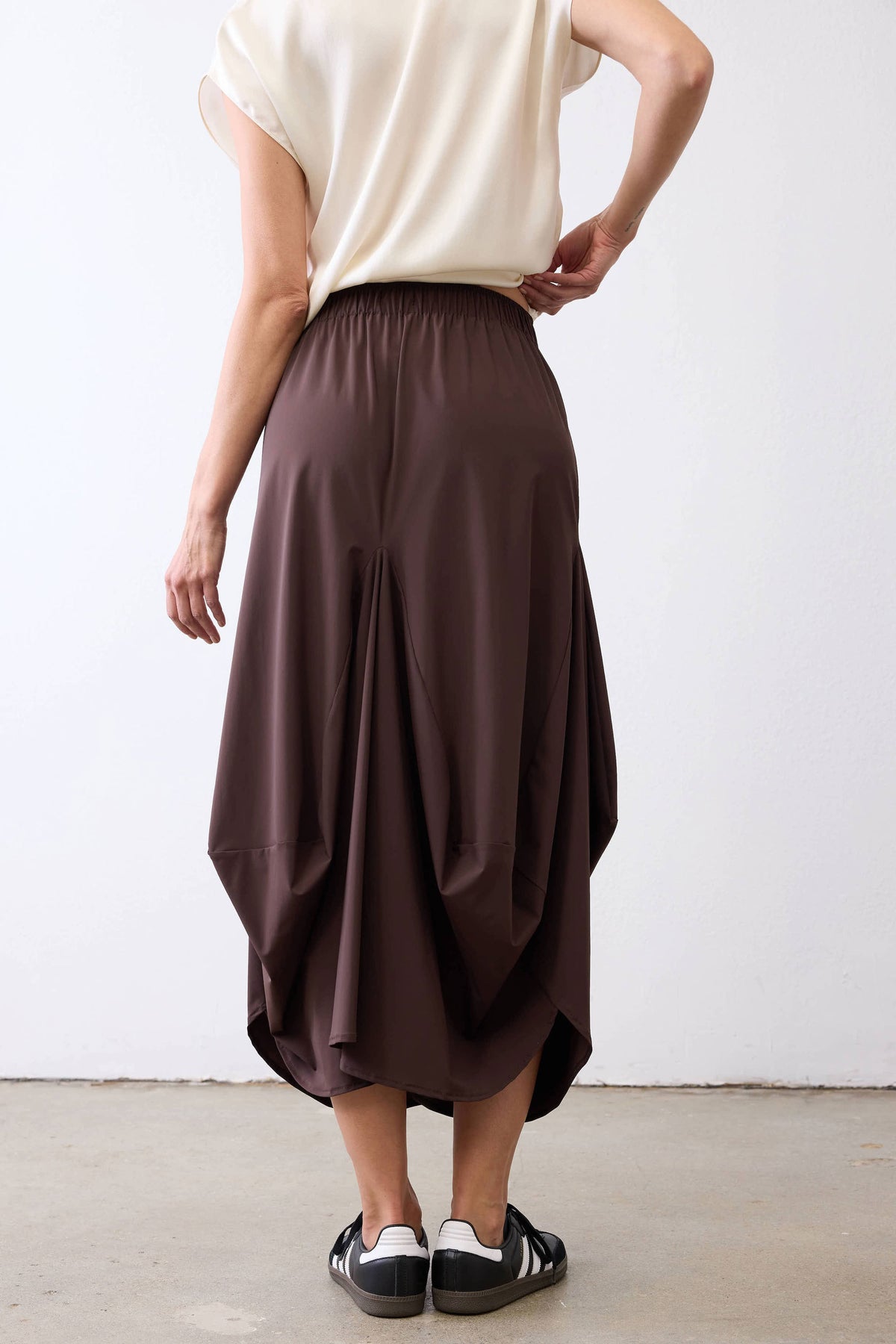 Coffee-brown skirt with gathered elastic waistband and draped, balloon-like midi silhouette