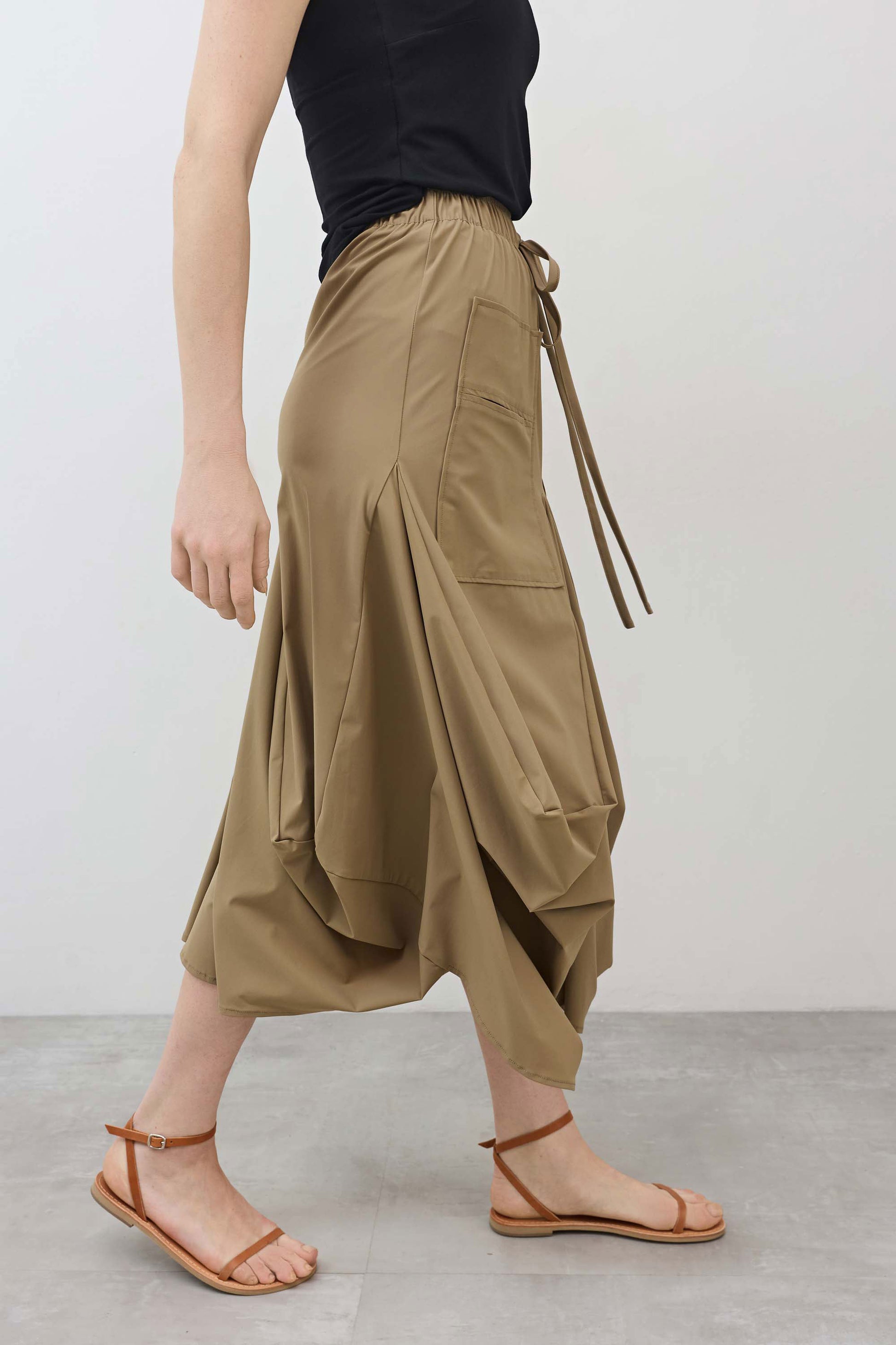 Petite go-to skirt with drawstring waist, side utility pockets, and asymmetrical drape hem
