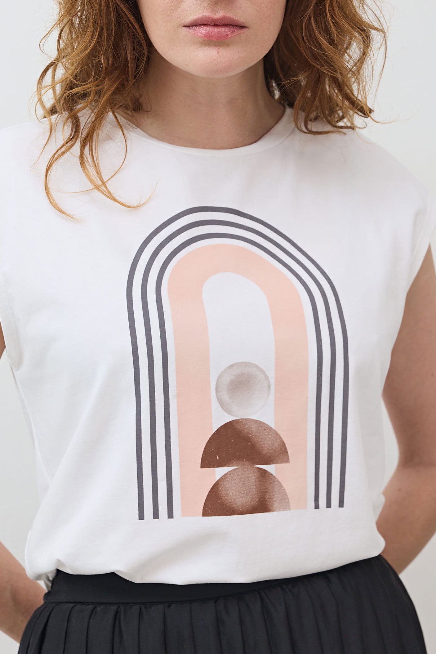 White sleeveless graphic tee with large rainbow arch graphic on the chest