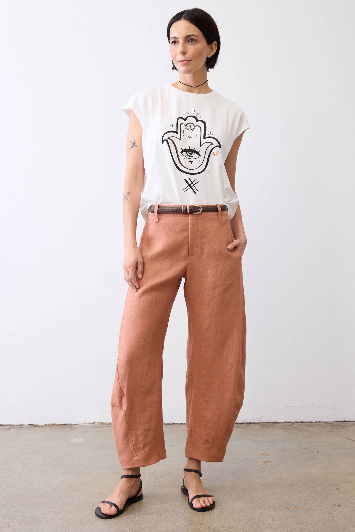 White graphic tee with Hamsa hand-eye design on the front, short sleeves