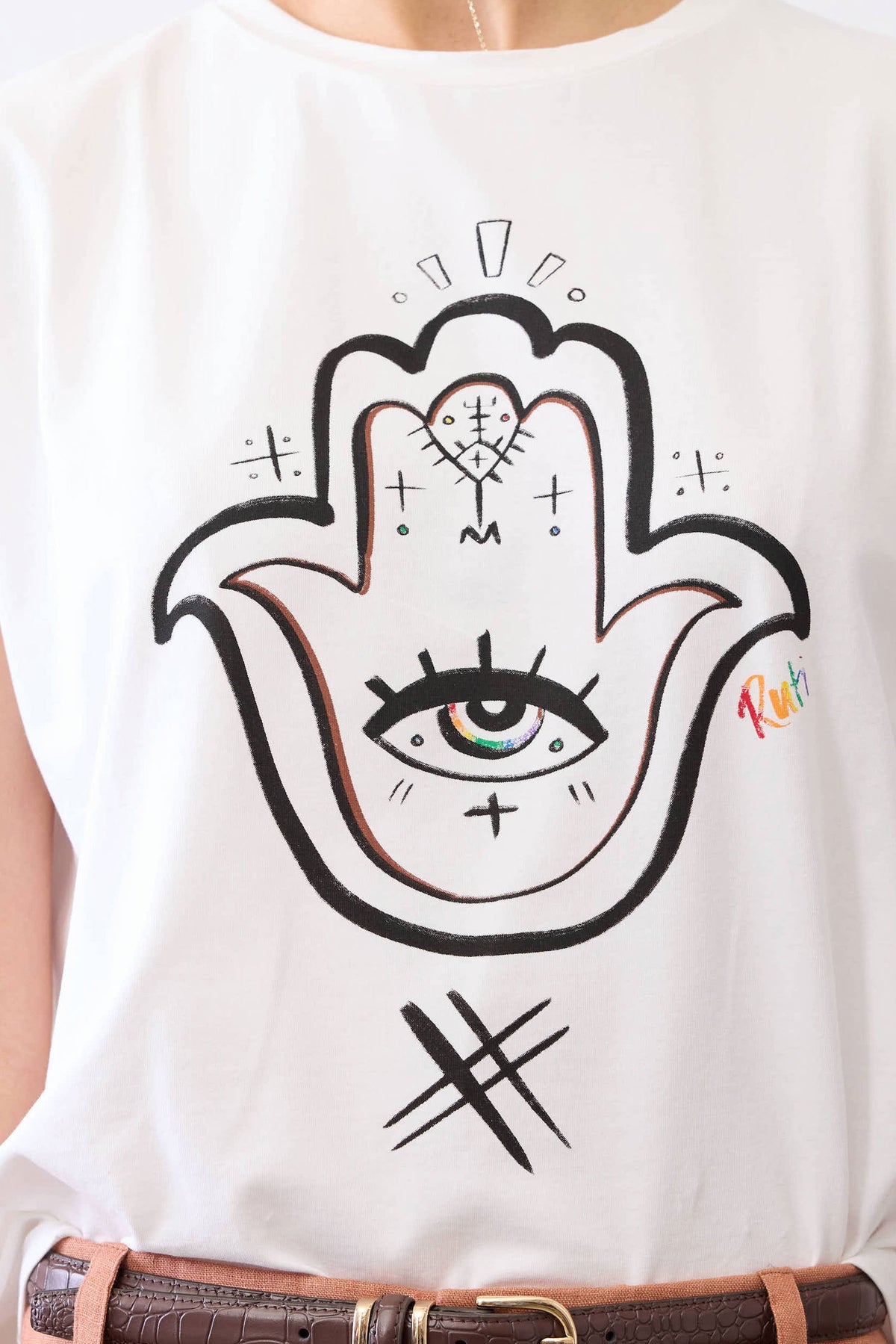 White short-sleeve tee with black Hamsa hand-eye graphic and decorative sparkles