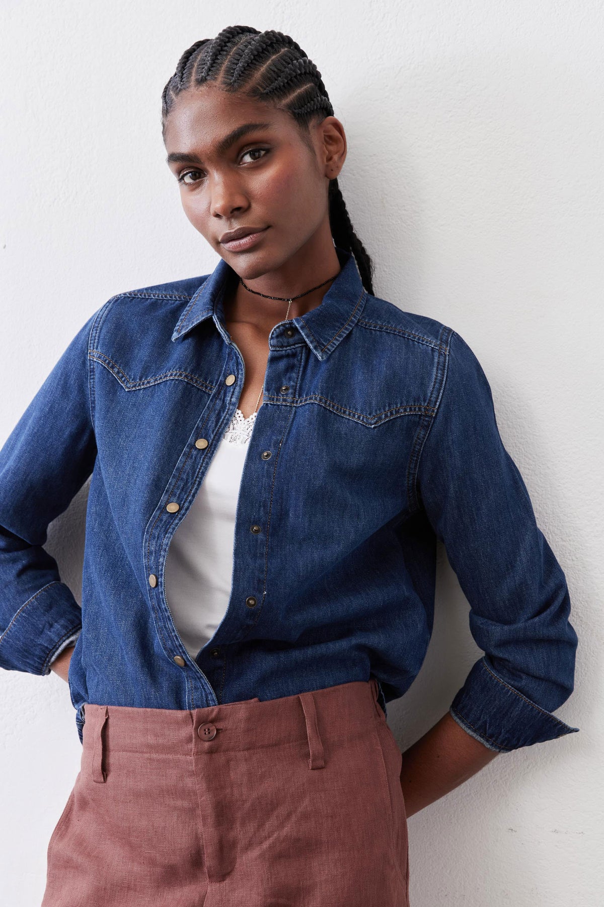 Medium-wash denim shirt with pointed collar, buttoned placket, and chest yoke seam