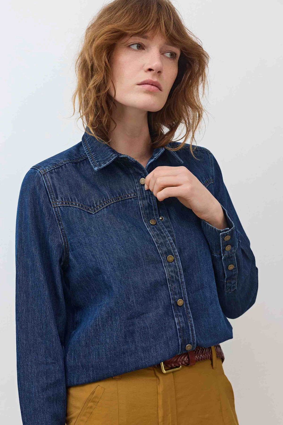 Medium-wash denim shirt with buttoned front and chest pocket seam detail