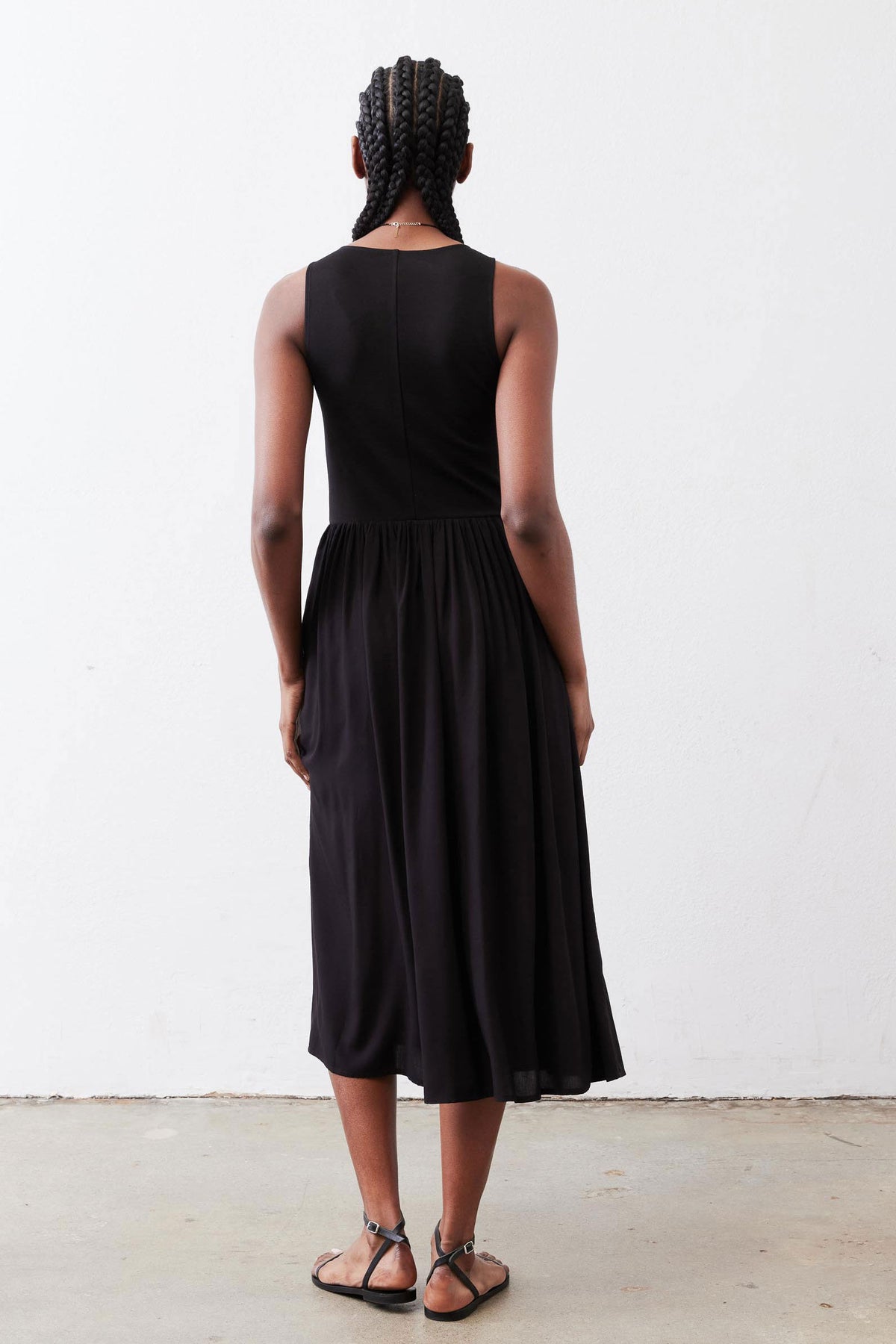 Black high-neck tank dress with gathered skirt, sleeveless back view