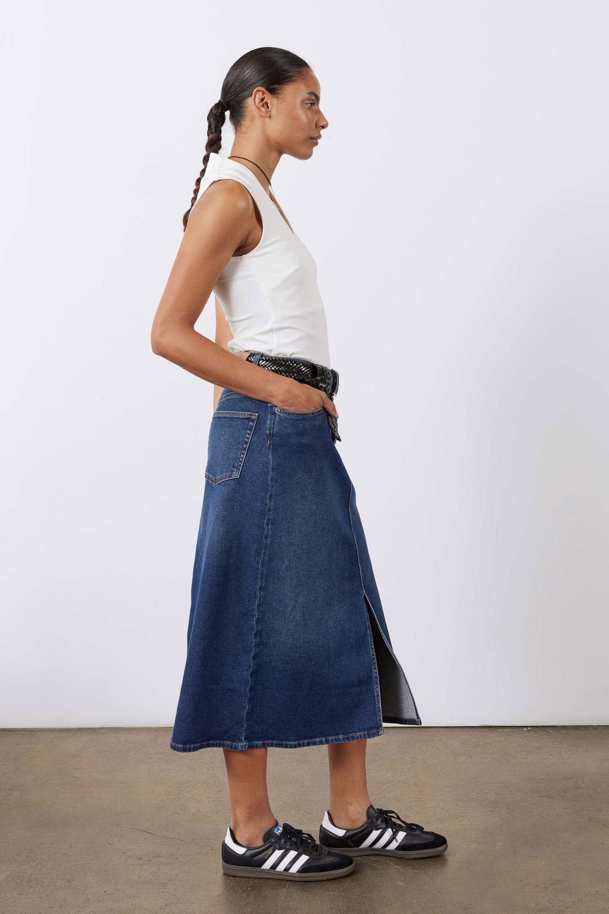 Women’s denim midi skirt with front slit, patch pockets, and belted waist