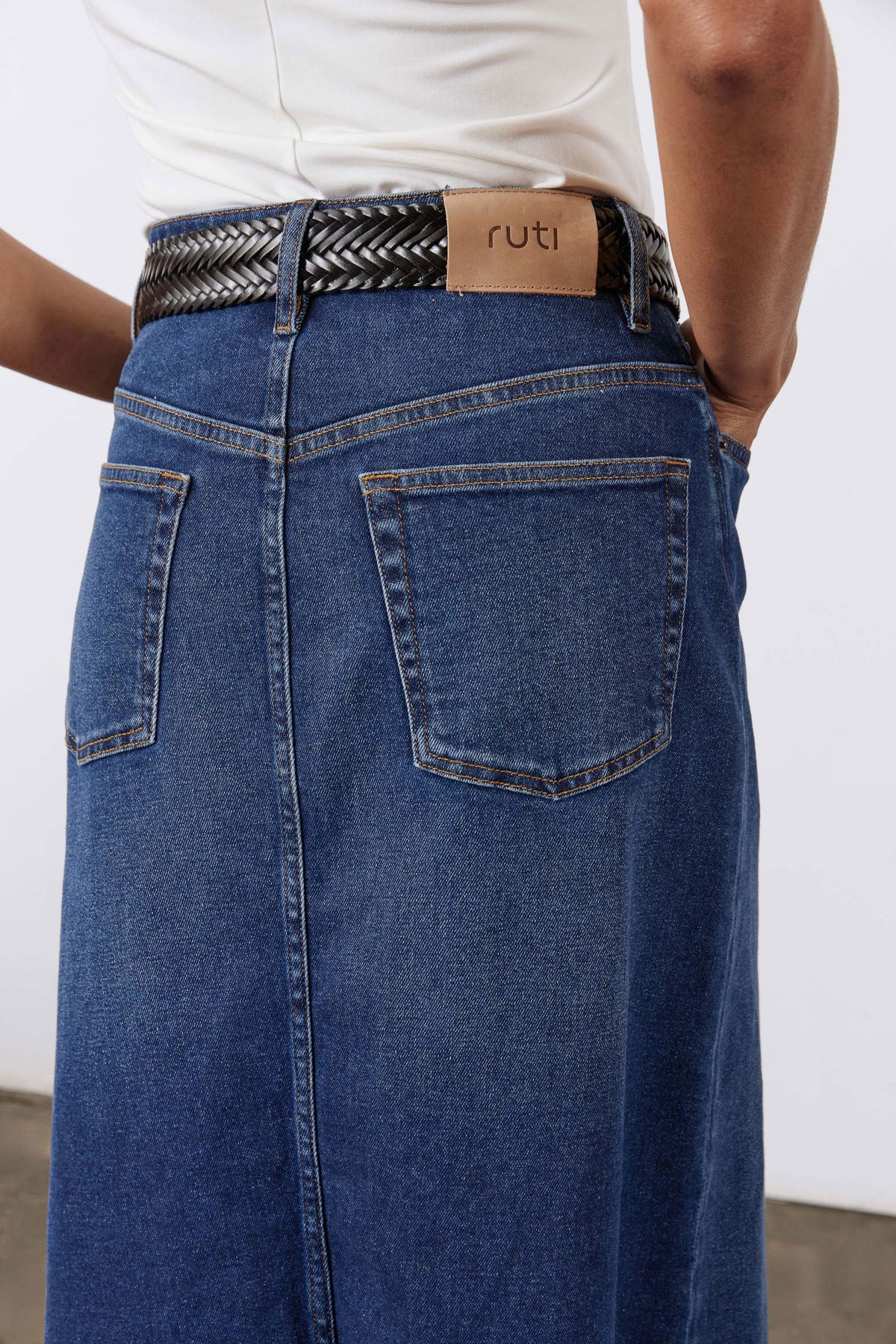 Women’s denim midi skirt back close-up in medium wash blue with back patch pocket