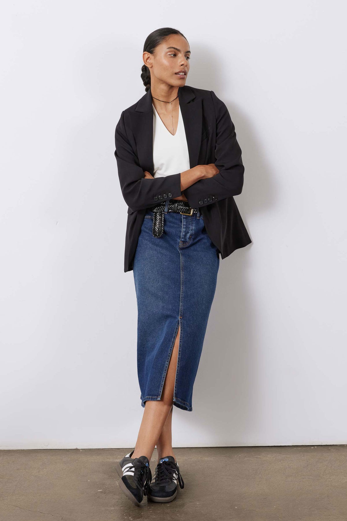 Women’s medium-wash denim midi skirt with front slit and woven belt detail